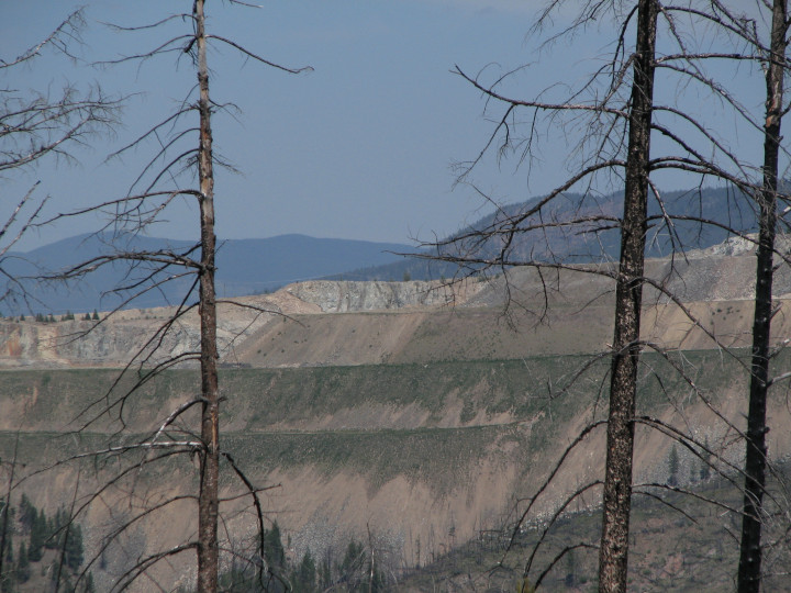 Photo of a a mountain removed and replaced
                    wandering qalong the edge of a as tailings for a
                    copper mine